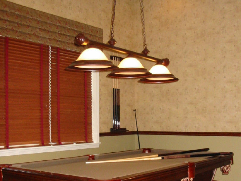 Tailored Roman style valance with wood blinds in a billiards room